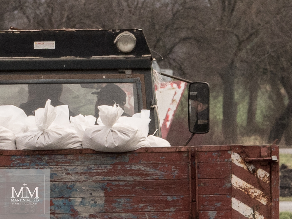 White sacks on a flatbed behind a tractor. Photograph created with the Olympus M. Zuiko digital ED 40 - 150 mm 1:2.8 PRO.